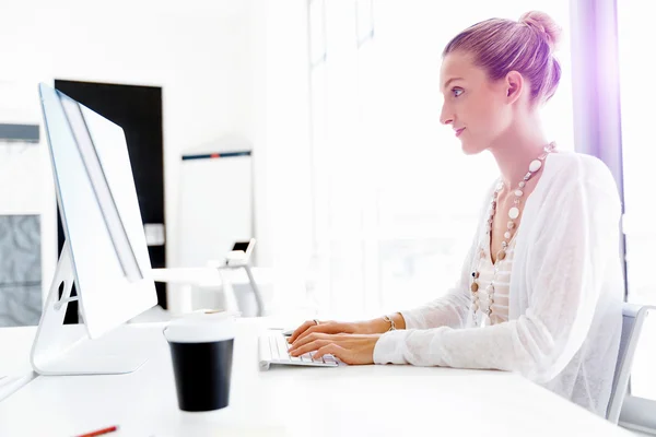 Attraktive Büroangestellte am Schreibtisch — Stockfoto