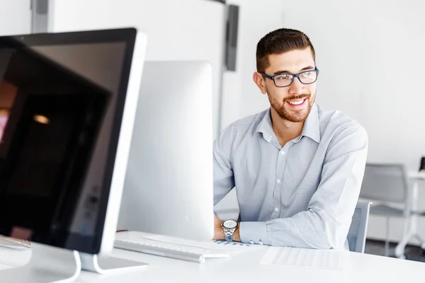 Männliche Büroangestellte sitzt am Schreibtisch — Stockfoto