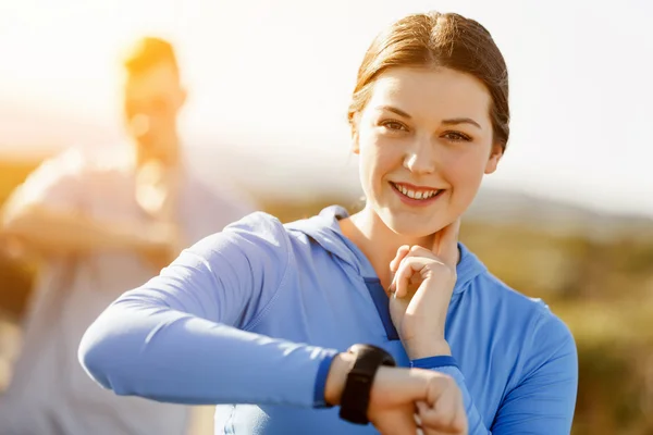 Runner donna con cardiofrequenzimetro in esecuzione sulla spiaggia — Foto Stock