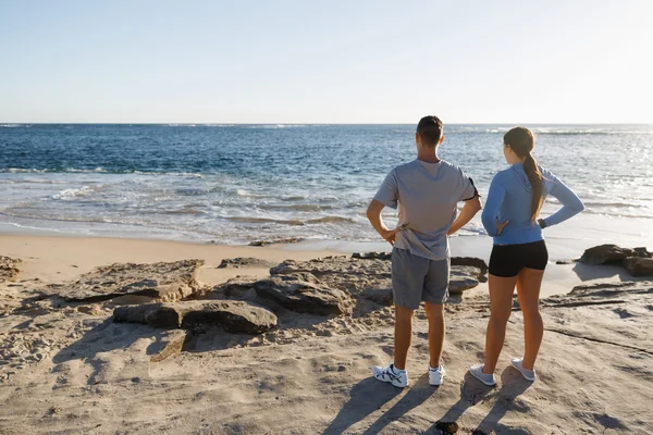 Jong (echt) paar op het strand training samen — Stockfoto