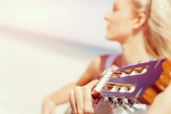 Belle jeune femme jouant de la guitare sur la plage — Photo