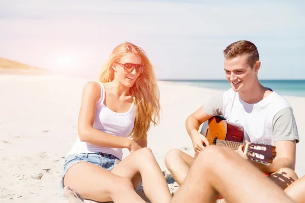 Hermosos jóvenes con guitarra en la playa — Foto de Stock