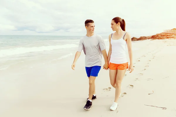 Corredores. Pareja joven corriendo en la playa —  Fotos de Stock