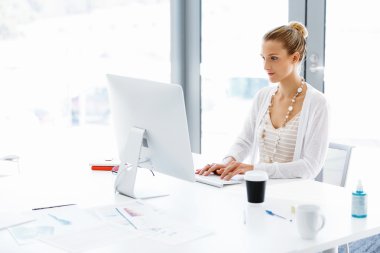 Çekici ofis çalışanı masada oturuyor.