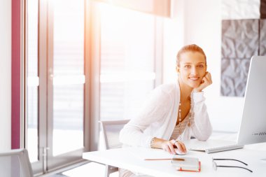 Çekici ofis çalışanı masada oturuyor.