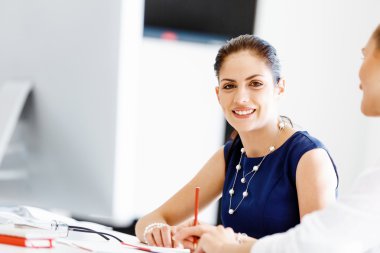 Çekici ofis çalışanı masada oturuyor.