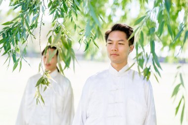 Yakışıklı adam Thai Chi yapıyor.