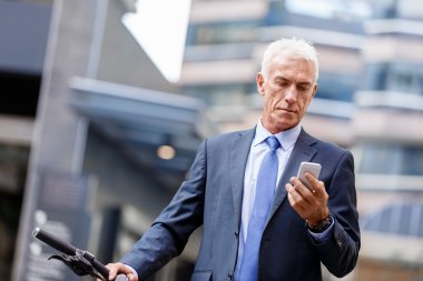 Cep telefonu ile bisiklet üzerinde başarılı iş adamı