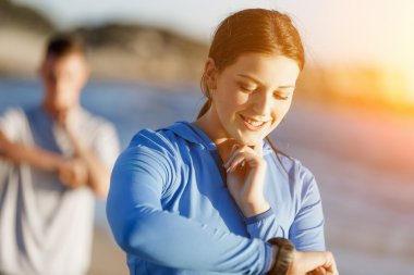 Kalp atış hızı monitörünü plajda çalışan kadınla Runner