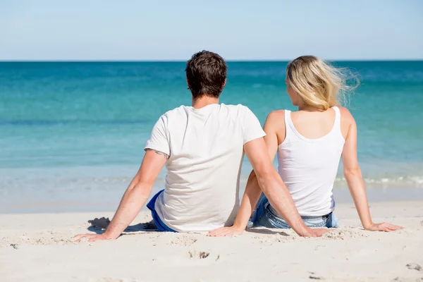 Romantique jeune couple assis sur la plage — Photo