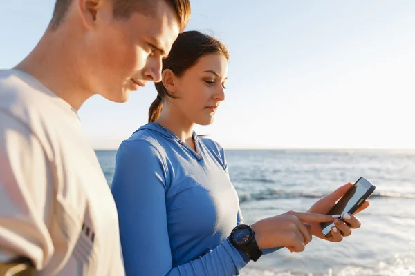 Jeune couple avec smartphones en plein air — Photo