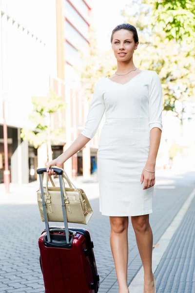 Mujer de negocios tirando del bolso de la maleta caminando en la ciudad —  Fotos de Stock