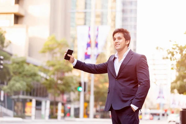 Businessman catching taxi in city — Stock Photo, Image