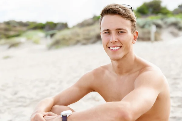 Knappe man die zich voordeed op strand — Stockfoto