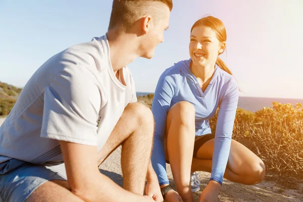 Coppia di corridori stringersi le scarpe e prepararsi a fare jogging — Foto Stock