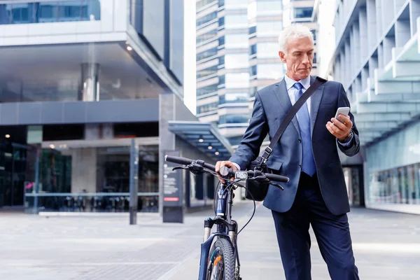 Empresário bem sucedido na bicicleta com telefone celular — Fotografia de Stock