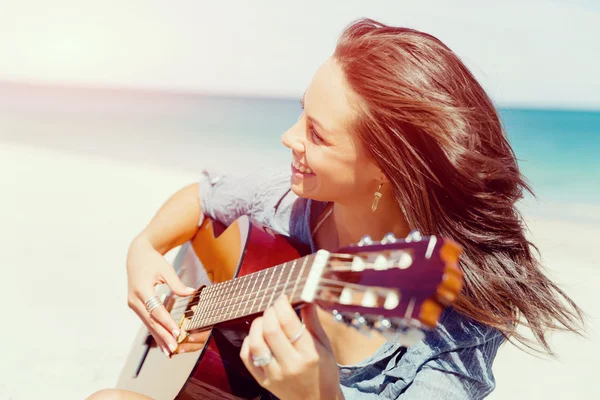 Belle jeune femme jouant de la guitare sur la plage — Photo