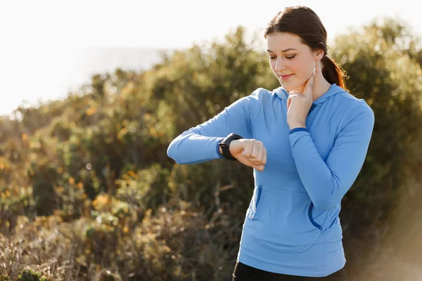 Loper vrouw met hartslagmeter uitgevoerd op strand — Stockfoto