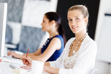 Çekici ofis çalışanı masada oturuyor.