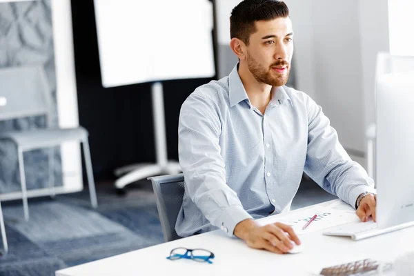 Männliche Büroangestellte sitzt am Schreibtisch — Stockfoto