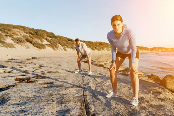 Junges Paar trainiert gemeinsam am Strand — Stockfoto
