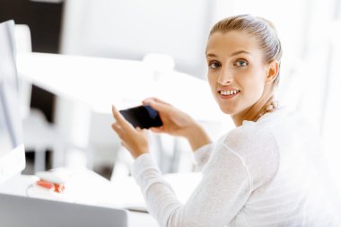 Çekici ofis çalışanı masada oturuyor.