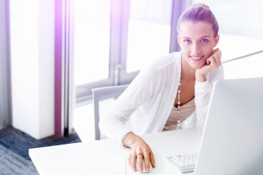 Çekici ofis çalışanı masada oturuyor.