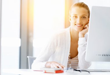 Çekici ofis çalışanı masada oturuyor.