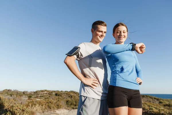 Loper vrouw met hartslagmeter uitgevoerd op strand — Stockfoto