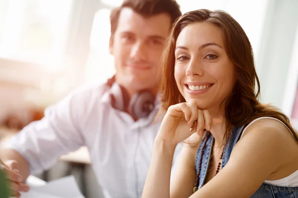 Jovem mulher bonita sorrindo com o homem no fundo — Fotografia de Stock