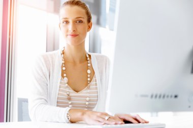 Çekici ofis çalışanı masada oturuyor.