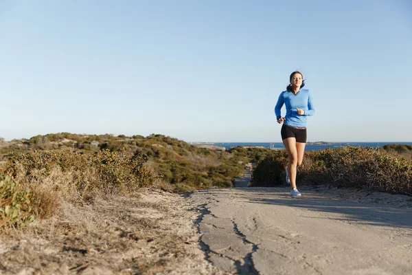 Corredor deportivo trotando en la playa haciendo ejercicio — Foto de Stock