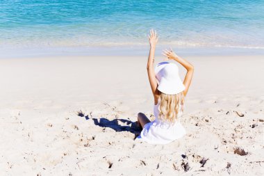 Genç bir kadın sahilde dinleniyor.