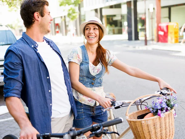 Happy couple in city with bike — Stock Photo, Image