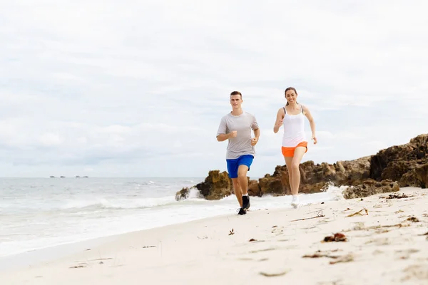 Δρομείς. Νεαρό ζευγάρι τρέχει στην παραλία — Φωτογραφία Αρχείου