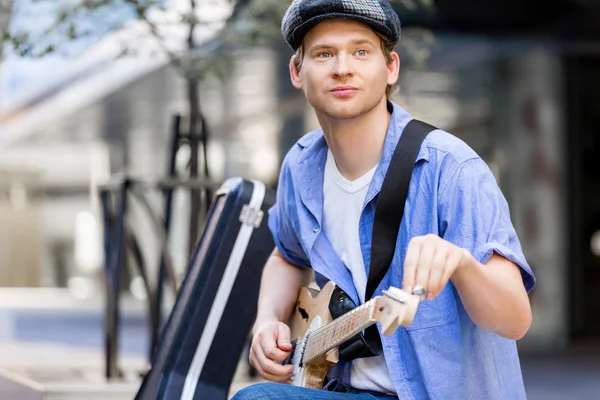 Young musician with guitar in city — Stock Photo, Image