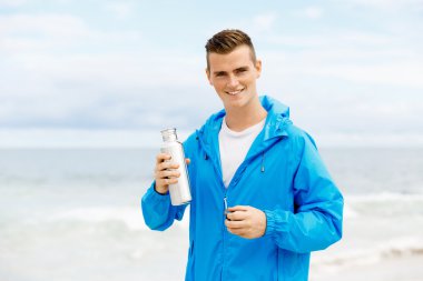 Şişe su ile tutarak kendine güvenen genç adam