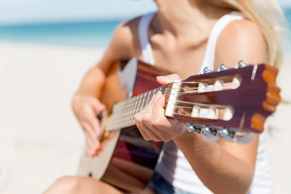 Piękna młoda kobieta gra na gitarze na plaży — Zdjęcie stockowe