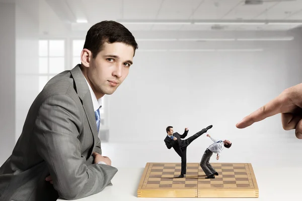 Businessman fighting on the chessboard — Stock Photo, Image