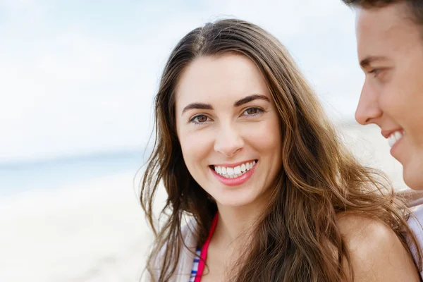 Romantische jonge paar zittend op het strand — Stockfoto