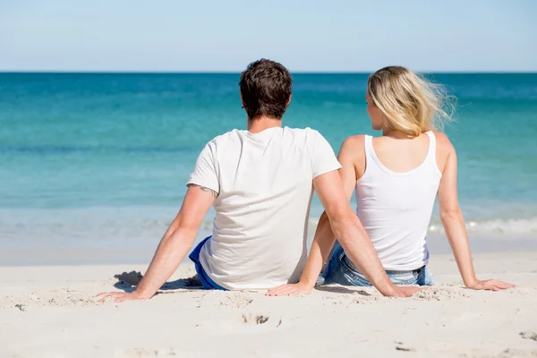 Romantikus, fiatal pár ül a strandon — Stock Fotó