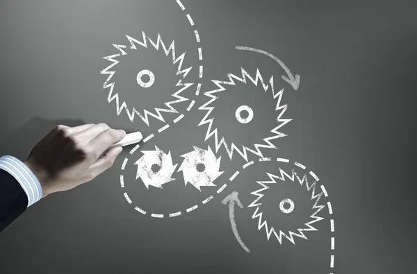 Man drawing gears on blackboard — Stock Photo, Image