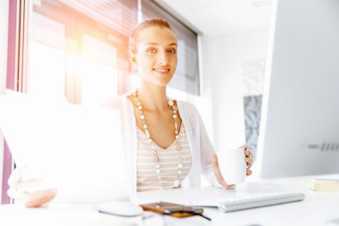 Çekici ofis çalışanı masada oturuyor.