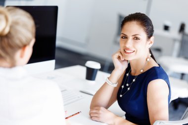 Çekici ofis çalışanı masada oturuyor.