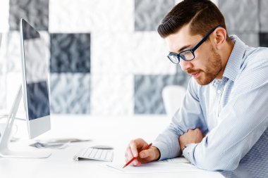 Masa başında oturan erkek ofis çalışanı