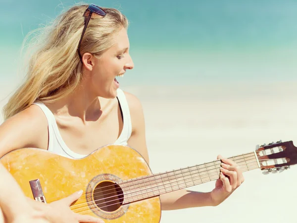 Belle jeune femme jouant de la guitare sur la plage — Photo