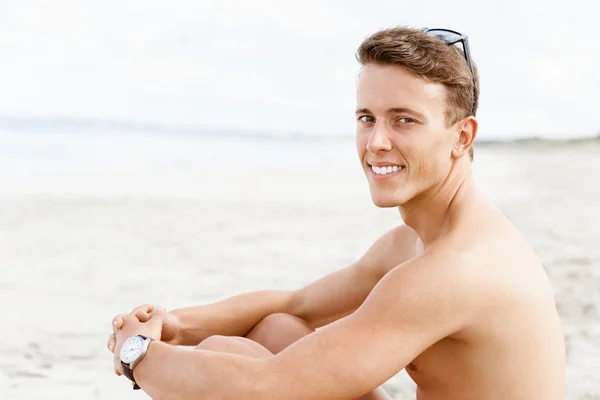 Knappe man die zich voordeed op strand — Stockfoto