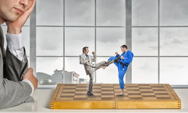 Empresario luchando en el tablero de ajedrez —  Fotos de Stock