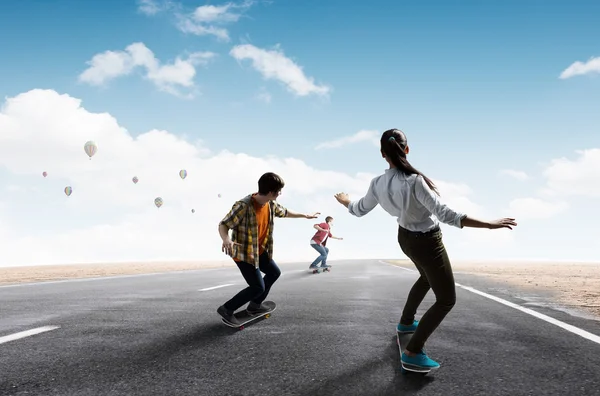 Mladí lidé na koni skateboard — Stock fotografie