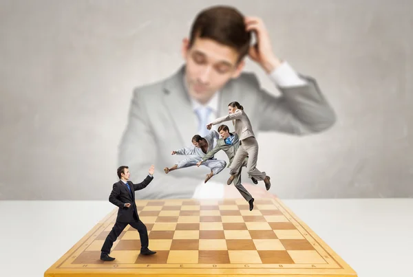 Бизнесмен сражается на шахматной доске — стоковое фото